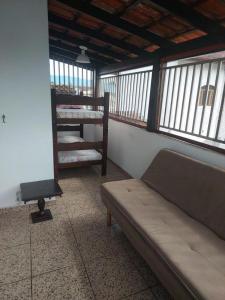 a room with a couch in a room with windows at Pousada Litoral Norte Caragua in Caraguatatuba