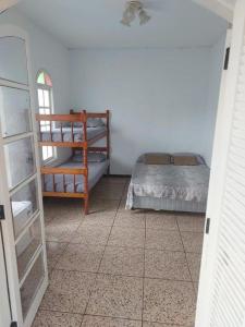 um quarto com uma cama e um espelho em Pousada Litoral Norte Caragua em Caraguatatuba