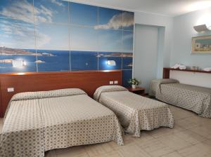 two beds in a room with a painting on the wall at Hotel Industria in Brescia