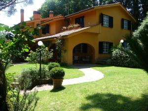 ein großes gelbes Haus mit einem Weg im Hof in der Unterkunft Deliziosa Villa alle porte di Roma in Procoio Nuovo