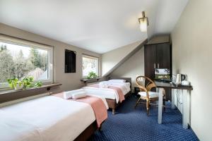 クリニツァ・ズドルイにあるPensjonat Orleのベッド4台、デスク、窓が備わる客室です。