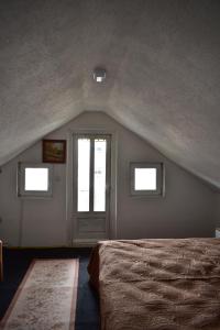 a bedroom with a bed and two windows and a door at Prenoćište Delija 020 in Sjenica