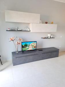 a living room with a tv on a table at Perla di Mare in Castel di Tusa