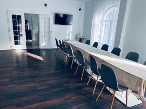 uma sala de conferências com uma mesa longa e cadeiras em Pensiunea La Brazi em Manastirea Humor