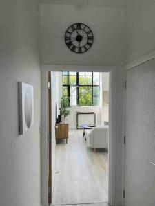 Habitación con reloj en la pared y sala de estar. en Art deco lodging in London en Hayes