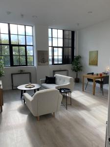 una sala de estar con sofás, mesas y ventanas en Art deco lodging in London en Hayes