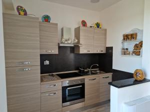 a kitchen with wooden cabinets and a sink and a stove at Podere 660 appartamento il Giuggiolo in Marrucheto