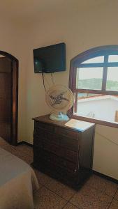 um quarto com uma cama e uma televisão numa cómoda em Pousada Litoral Norte Caragua em Caraguatatuba