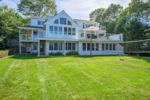 a large white house with a large yard at Relax by the Lake: Private Beach Views in Centerville