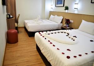 una camera d'albergo con due letti con cuori sopra di ECO HOTEL at BUKIT BINTANG a Kuala Lumpur