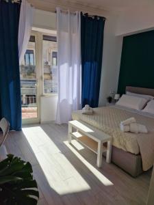 a bedroom with a large bed and blue curtains at La Stazione 92 in Catania