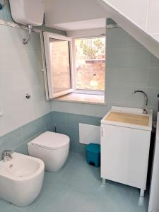 een badkamer met een toilet, een wastafel en een raam bij Perla di Mare in Castel di Tusa