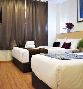 a room with three beds and atained at ECO HOTEL at BUKIT BINTANG in Kuala Lumpur