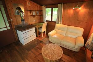 - un salon avec un canapé et une table dans l'établissement Cabane au cœur de la forêt des Landes de Gascogne, à Belin-Beliet