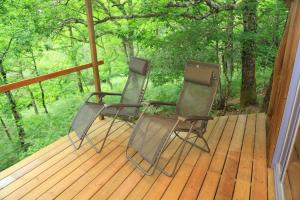 deux chaises assises sur une terrasse arborée dans l'établissement Cabane au cœur de la forêt des Landes de Gascogne, à Belin-Beliet