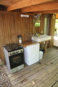 une cuisine extérieure avec une cuisinière et un évier dans l'établissement Cabane au cœur de la forêt des Landes de Gascogne, à Belin-Beliet