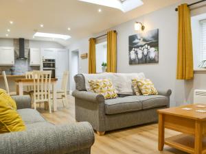 a living room with a couch and a table at Bumble Cottage in Cockermouth
