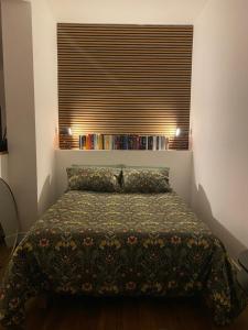 a bedroom with a bed and a window with books at LOFT MANZONI 37 in Cremona