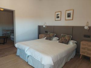 ein Schlafzimmer mit einem großen weißen Bett mit zwei Kissen in der Unterkunft El Balcón de la Vega in Pareja