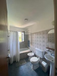 a bathroom with a toilet and a sink and a tub at Casa Storni in Mar del Plata