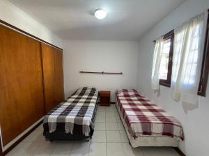 two beds sitting in a room with a window at Casa Storni in Mar del Plata +5 photos