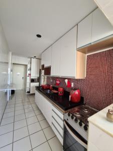 cocina grande con armarios blancos y azulejos rojos en Praia do Morro Guarapari, en Guarapari