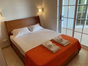 1 dormitorio con 1 cama con 2 toallas en A Casa do Carlos, en Vila Nova de Cacela