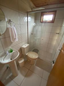 ein weißes Bad mit einem WC und einem Waschbecken in der Unterkunft Chalé Campos Da Serra in São José dos Ausentes