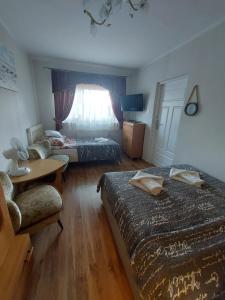 a hotel room with two beds and a table at LENA pokoje gościnne in Międzyzdroje