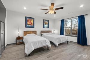 a bedroom with two beds and a ceiling fan at Alyce GreenView- Views of nature in Bella Vista