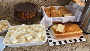 a table with a tray of bread and a cake at Hotel Eldorado in Maracás