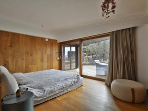 ein Schlafzimmer mit einem Bett und einem großen Fenster in der Unterkunft Casa japandi Un alojamiento saludable in Sant Juliá de Vilatorta