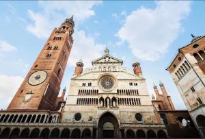 a building with two towers and a clock tower at LOFT MANZONI 37 in Cremona