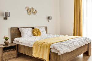 um quarto com uma cama com um cobertor amarelo em ARI Central Green Apartment em Arad