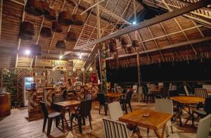 a restaurant with tables and chairs in a room at Biohotel Arara River in Leticia