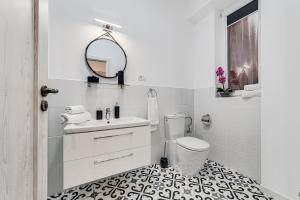 a white bathroom with a sink and a toilet at ARI Central Green Apartment in Arad