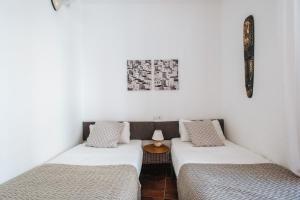 - 2 lits dans une chambre aux murs blancs dans l'établissement Bright Apartment at Santa Cruz 6 pax, Parking Optional, à Séville