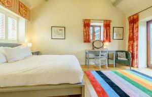 a bedroom with a bed and a desk and a chair at Coursehill Barn in Witney