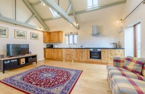 a large living room with a couch and a tv at Coursehill Barn in Witney
