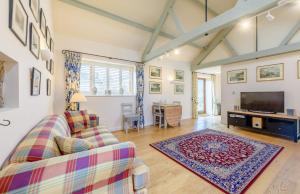 a living room with a couch and a tv at Coursehill Barn in Witney