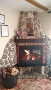 a stone fireplace with a fire in a room at Apartamentos El Callejón in Riópar