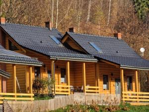 Cabaña de madera con techo negro en Domki pod Jaworem Brenna, en Brenna