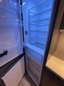 een lege koelkast met de deur open in een keuken bij Solbergs, fint attefallshus i Vik, Åre in Åre