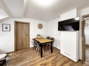 ein Esszimmer mit einem Tisch, Stühlen und einem TV in der Unterkunft Apartment KATRIN 2 in Karlsbad