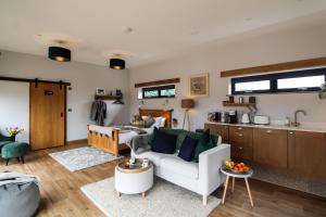 a living room with a couch and a kitchen at The Tin Shed in Rhayader