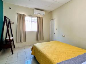 um quarto com uma cama amarela e uma janela em Zamá house em Palenque