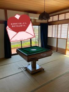 a ping pong table in a room with a sign at 高島市一棟貸切 Biwa Lake琵琶湖 徒歩10分 大人数でご利用だとお得連泊がお得BBQ麻雀可能自転車無料利用可 in Takashima