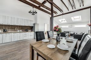 a kitchen and dining room with a wooden table and chairs at ARI Central Skyview Apartment in Arad