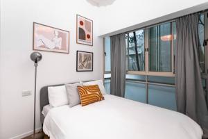 a bedroom with a white bed and a window at Stylish apartment in the center of Tel-Aviv. in Tel Aviv