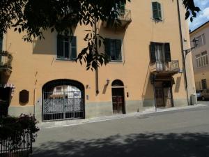 a building with doors and windows on a street at Monolocale San Guido in Acqui Terme